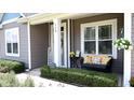 Inviting porch with seating, decorative pillows, and a hanging flower basket at 112 Star Valley Dr, Angier, NC 27501