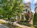 Charming two-story home featuring a covered front porch, manicured lawn, and mature trees at 1705 Green Oaks Pkwy, Holly Springs, NC 27540