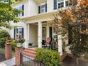 Inviting front porch with seating area, brick pillars, and a view of the landscaped yard at 1705 Green Oaks Pkwy, Holly Springs, NC 27540