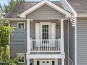 A close-up shot of a charming covered front porch with white columns, a door and a light fixture at 185 Sioux Ln, Clayton, NC 27520