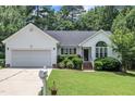 Home featuring a manicured lawn, attached garage, and well-maintained landscaping at 2003 Zbonack Ct, Creedmoor, NC 27522