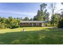 Charming brick home with a lush, green front yard and mature trees at 3603 Grimes Ave, Durham, NC 27703