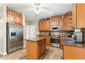 Open kitchen featuring hardwood floors, stainless steel appliances, and an island at 701 Oakhall Dr, Holly Springs, NC 27540