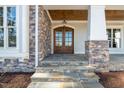 Elegant front entrance with stone accents and double doors at 291 Riverstone Dr, Pittsboro, NC 27312
