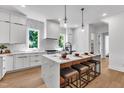 Bright kitchen featuring a large island with seating, pendant lights, sleek white cabinets, and modern fixtures at 2601 Mayview Rd, Raleigh, NC 27607