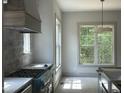 Gourmet kitchen features stainless steel appliances, ample counter space, and a stylish range hood at 57 Hazelwood, Pittsboro, NC 27312