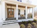 Inviting front porch with stone floor, wooden door, and a bench, offering a cozy welcome at 167 Edgefield St, Pittsboro, NC 27312