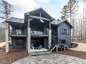 Spacious backyard featuring a covered patio, stone pillars, and access to the upper balcony at 75 Ridgeline Ct, Pittsboro, NC 27312