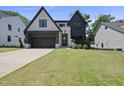 Striking home with a modern facade, dark accents, lush lawn, and a welcoming entrance at 5307 Dixon Dr, Raleigh, NC 27609