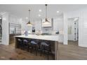 Bright, all-white gourmet kitchen featuring a large island with seating and stainless steel appliances at 5307 Dixon Dr, Raleigh, NC 27609