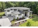 Beautiful home exterior featuring a three-car garage with modern glass doors and professionally landscaped yard at 213 Westhampton Dr, Pittsboro, NC 27312