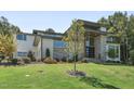 Front exterior showcasing the modern design with stone accents, ample windows, and a well-maintained lawn at 213 Westhampton Dr, Pittsboro, NC 27312