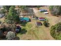 Aerial view of the home on a spacious lot with multiple outbuildings and mature trees at 5027 Lake Willett Rd, Sanford, NC 27332