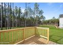 A spacious wood deck overlooks the home's green backyard and tall trees at 228 Rocking Horse Ln, Sanford, NC 27332