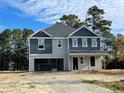 Two-story house with gray and blue siding, attached garage, and partially landscaped yard at 2833 Sheriff Watson Rd, Sanford, NC 27332