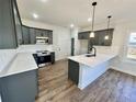 Modern kitchen with sleek gray cabinetry, white countertops, stainless steel appliances, and new hardwood floors at 35 Fort Mcclary Ct, Cameron, NC 28326