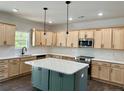 Modern kitchen with light wood cabinets, green island, and stainless steel appliances at 36 Fort Mcclary Ct, Cameron, NC 28326