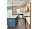 Modern kitchen with light wood cabinets, green island, and stainless steel appliances at 36 Fort Mcclary Ct, Cameron, NC 28326