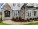 Close-up of the exterior details showing stone accents, gray siding, and manicured landscaping at 25 Cotton Fields Ln, Fuquay Varina, NC 27526
