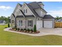 Beautiful home showcasing a three car garage and stone exterior accents at 25 Cotton Fields Ln # 29, Fuquay Varina, NC 27526