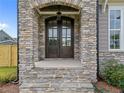 Inviting front entryway featuring a stone archway and a gorgeous wood door at 25 Cotton Fields Ln # 29, Fuquay Varina, NC 27526