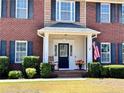 Inviting front entrance with a charming porch and American flag at 11 Antique Ct, Cameron, NC 28326