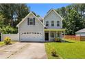 Charming two-story home featuring a well-manicured lawn and a two-car garage at 60 Hunters Way, Angier, NC 27501