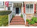 Close-up view of the front entrance featuring brick steps, white railings, and a dark front door at 367 Falling Water Rd, Spring Lake, NC 28390