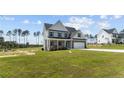 Two story house with gray siding, stone accents, and a two car garage at 830 Cypress Rd, Cameron, NC 28326