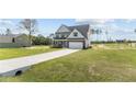 Two story house with gray siding, stone accents, and a two car garage at 830 Cypress Rd, Cameron, NC 28326