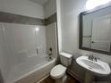 Clean bathroom with a white tub, sink, and mirror at 114 Kingwood Dr, Lillington, NC 27546