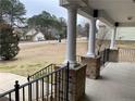 Covered porch with brick columns and black railings at 708 Omaha Dr, Broadway, NC 27505