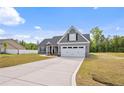 Charming single-Gathering home boasts a manicured lawn, long drive way and a mix of stone and vinyl siding at 167 Thistle Ct, Sanford, NC 27332