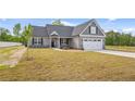 Charming single-Gathering home boasts a manicured lawn, attached two car garage, and a mix of stone and vinyl siding at 167 Thistle Ct, Sanford, NC 27332