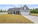 Charming single-Gathering home boasts a manicured lawn, attached two car garage, and a mix of stone and vinyl siding at 167 Thistle Ct, Sanford, NC 27332