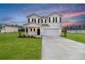 Beautiful home showcasing its white siding, black shutters, and fresh landscaping against a colorful sky at 64 Onslow Ct, Spring Lake, NC 28390
