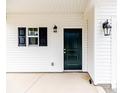 Close-up of the elegant front door with a black finish, complemented by stylish black sconces and shutters at 64 Onslow Ct, Spring Lake, NC 28390