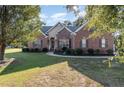 Beautiful brick home with manicured front lawn and mature trees providing shade and curb appeal at 9404 Perimeter Ct, Zebulon, NC 27597