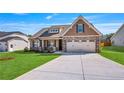 Charming single Gathering home with stone accents, a two-car garage and a well maintained lawn at 258 Thistle Ct, Sanford, NC 27332