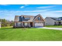 Charming single Gathering home with stone accents, a two-car garage and a well maintained lawn at 258 Thistle Ct, Sanford, NC 27332