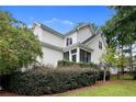 Rear view of charming home with a screened porch and a landscaped yard and mature trees at 197 Lamplighter Way, Spring Lake, NC 28390