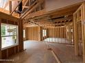 Bright living room highlighting exposed framing, large windows, and unfinished floors at 375 Graham Rd, Cameron, NC 28326