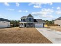 Traditional two-story home with a well-maintained lawn, inviting front porch and a convenient two-car garage at 732 Burley Oak Dr, Cameron, NC 28326