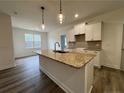 Kitchen features a granite island with pendant lighting and white cabinets with stainless steel appliances at 732 Burley Oak Dr, Cameron, NC 28326