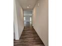 Long hallway with hardwood flooring leading to an open living area flooded with natural light at 8027 Royal Dr, Sanford, NC 27332