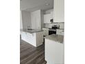 Bright kitchen with granite countertops, white cabinets, stainless steel appliances, and a spacious island at 8027 Royal Dr, Sanford, NC 27332