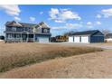 Two-story house with a detached garage, large yard, and light blue siding at 5554 Lake Vista Ct, Rocky Mount, NC 27803