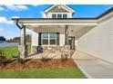 Inviting front porch features stone accents, decorative columns, and a cozy seating area by the front door at 32 Boyce Ct, Sanford, NC 27332