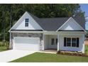Charming home featuring stone accents, a two-car garage, manicured lawn, and classic black shutters at 123 Nectar Ln, Bunnlevel, NC 28323