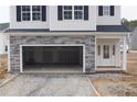 Two-story home featuring stone-accented garage and white siding, providing a classic aesthetic at 154 Nectar Ln, Bunnlevel, NC 28323